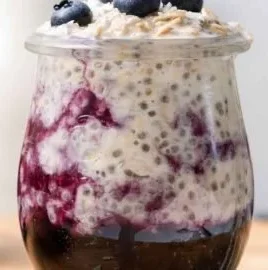 Bowl of creamy blueberry overnight oats topped with fresh blueberries and almonds