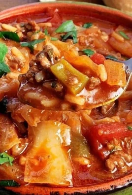 Cabbage soup with ground beef served in a bowl, garnished with herbs