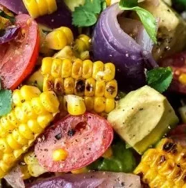 Charred corn avocado salad with roasted red onions in a bowl.