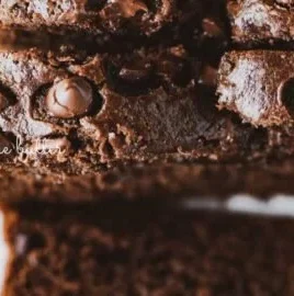 Slice of moist chocolate zucchini bread on a wooden cutting board