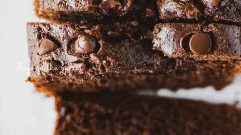 Slice of moist chocolate zucchini bread on a wooden cutting board