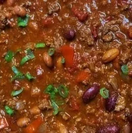 Bowl of classic slow cooker chili with toppings and herbs
