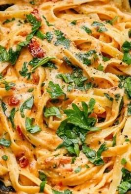 Creamy vegan sun-dried tomato pasta served in a bowl with fresh basil.