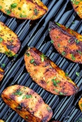 Crispy grilled potatoes on a serving plate with herbs and spices.