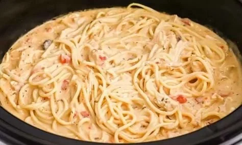 Crock Pot Cheesy Chicken Spaghetti served in a bowl with cheese and herbs