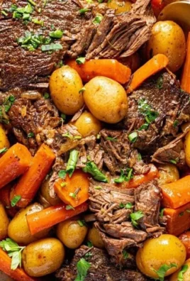 Crock pot pot roast with vegetables and herbs in a slow cooker