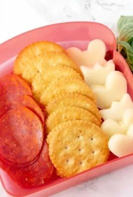 DIY Pizza Crackers Lunchable with cheese, pepperoni, and toppings