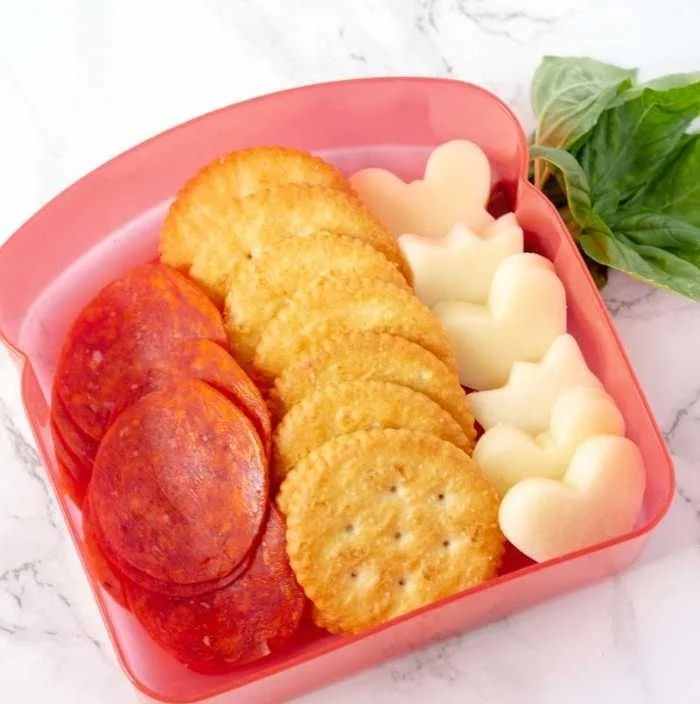 DIY Pizza Crackers Lunchable with cheese, pepperoni, and toppings