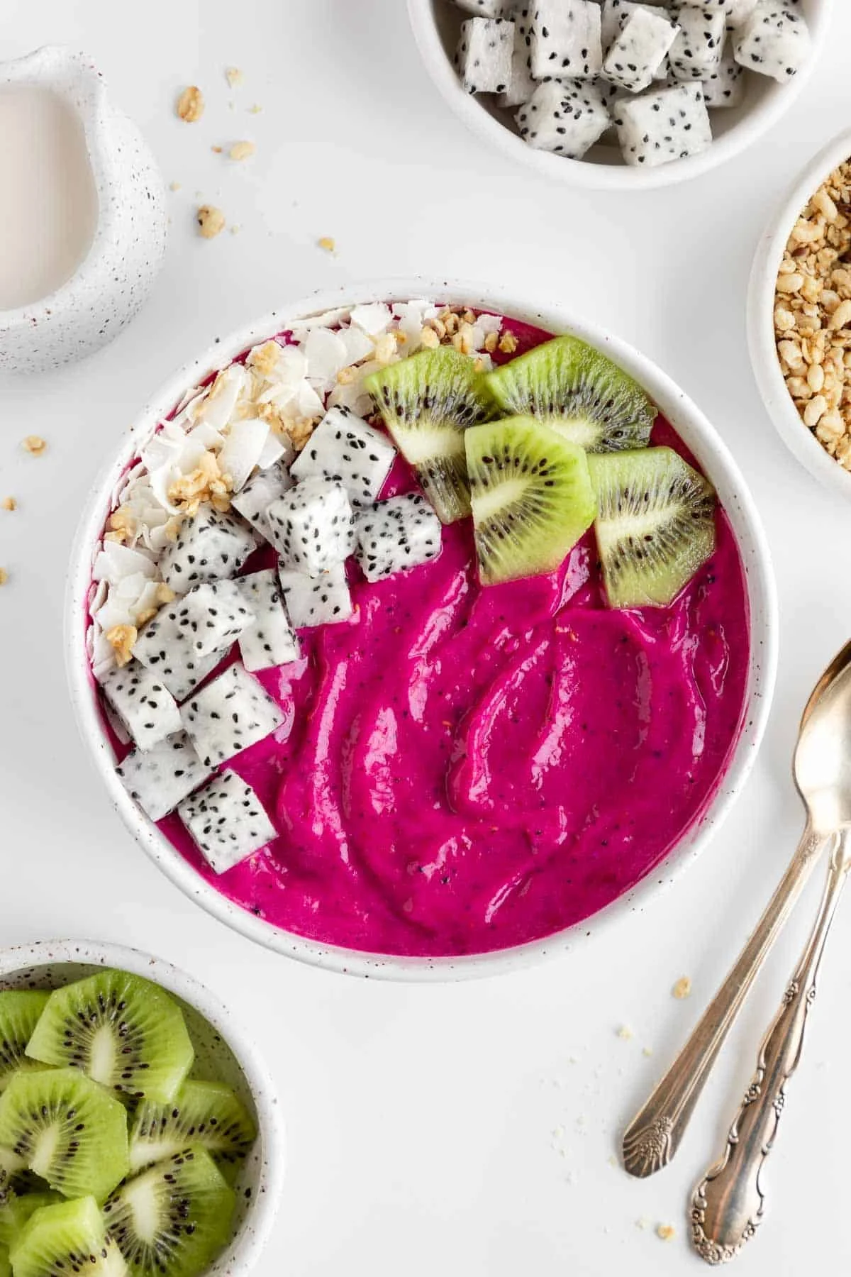 Colorful dragon fruit smoothie bowl topped with fresh fruits and nuts