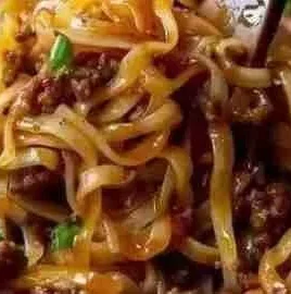 Plate of easy Mongolian ground beef noodles topped with green onions.