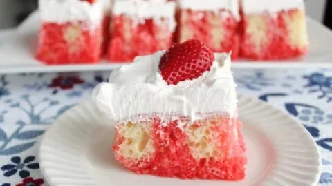 Easy Strawberry Poke Cake topped with fresh strawberries and whipped cream