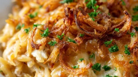 French Onion Chicken Orzo Casserole topped with melted cheese and onions