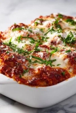 High protein chicken parmesan casserole topped with cheese and herbs.