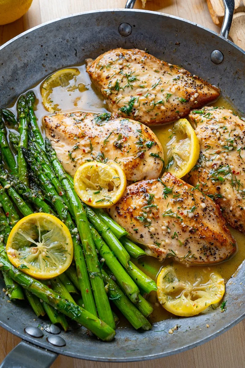 Lemon and dill butter garlic chicken with asparagus on a plate.