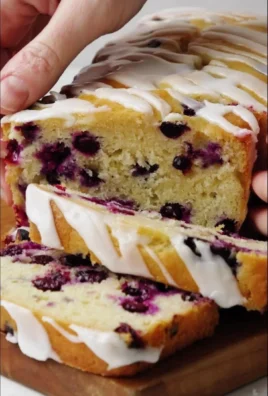 Slice of lemon blueberry bread with fresh blueberries on top