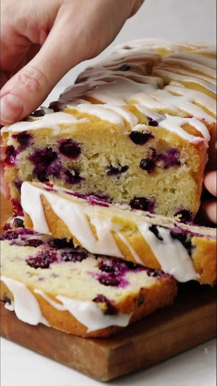 Slice of lemon blueberry bread with fresh blueberries on top