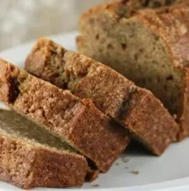 Delicious slice of Mom's Zucchini Bread on a wooden table