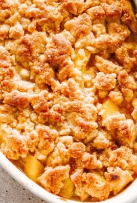 Delicious homemade peach cobbler served warm with ice cream.