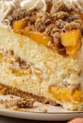 Delicious Peach Cobbler Cheesecake topped with fresh peaches and a crumbly crust
