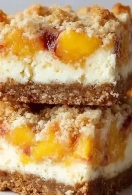 Delicious Peach Cobbler Cheesecake Bars topped with fresh peaches and crumble