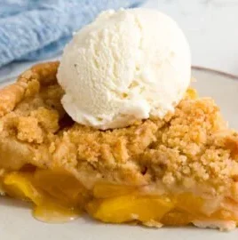 Homemade Peach Crumble dessert topped with golden crumble crust