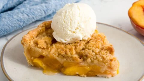 Homemade Peach Crumble dessert topped with golden crumble crust