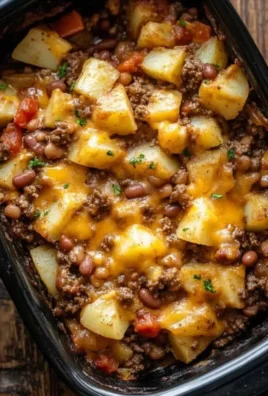 Delicious slow cooker cowboy casserole topped with cheese and garnished with herbs.