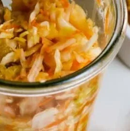 Bowl of spicy sauerkraut with ginger and garlic on a wooden table