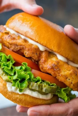 Ultimate crispy chicken sandwich with lettuce and pickles on a bun