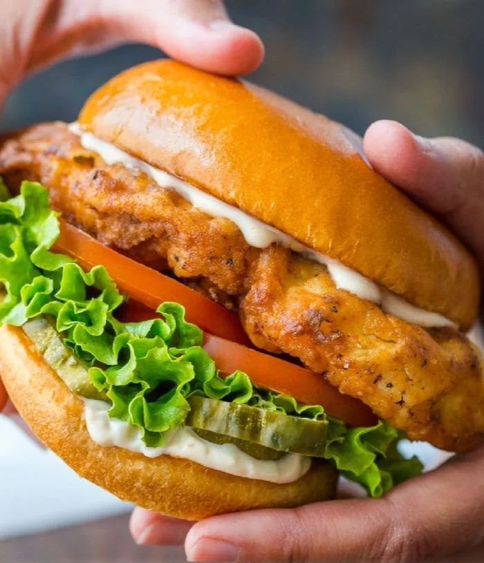 Ultimate crispy chicken sandwich with lettuce and pickles on a bun